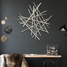 a room with a table, chair and wall decoration on the wall above it is a star made out of sticks