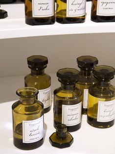 several bottles with labels on them sitting on a shelf