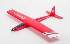 a red model airplane with writing on the wing and nose, sitting on a white surface