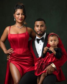 a man in a tuxedo poses with his wife and child