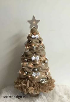 a small christmas tree with lights on it's sides and a star decoration above the top