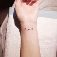 a woman's wrist with three birds on it