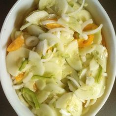 a white bowl filled with cabbage and oranges