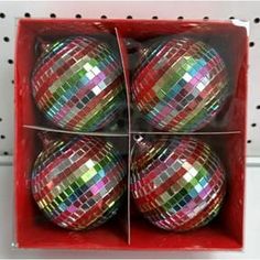 four shiny disco ball ornaments in a red box