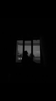 a person sitting in front of a window at night