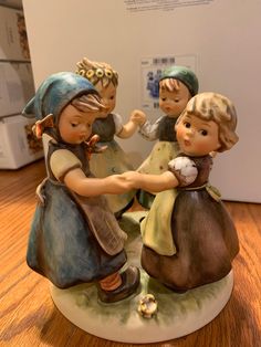 three figurines sitting on top of a wooden table