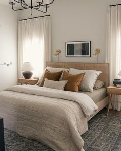 a bedroom with a bed, nightstands and two lamps on either side of the bed