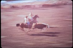 two men riding horses in an open field with no one on them or the horse is galloping