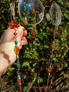 Introducing our new enchanting glasses chain, a mesmerizing accessory that captures the essence of fairy allure.  Adorned with maple leaf charms, dazzling teal, orange and red beads, and green tiger eye square beads, this glasses chain exudes an ethereal charm.  This eyeglass chain might be slightly heavier than regular chains because of some stone beads and crystals. Actual colors of any item or chains may slightly differ from screen to screen due to the screen resolution. I take our pictures i Handmade Bohemian Glasses Chains For Party, Bohemian Handmade Glasses Chains For Party, Handmade Elegant Glasses Chains For Festivals, Elegant Handmade Glasses Chains For Festivals, Elegant Handmade Festival Glasses Chains, Witchy Glasses, Glasses With Beads, Fairy Glasses, Fantasy Glasses