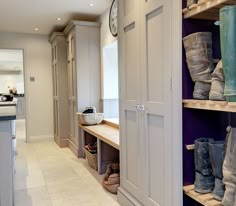 there are many pairs of shoes on the shelves in this kitchen and one is empty