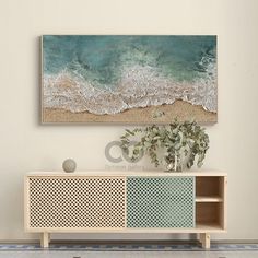 an ocean scene with waves crashing on the beach and a white vase in front of it