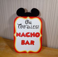 a sign that says oh toodles nacho bar with mickey mouse ears on it