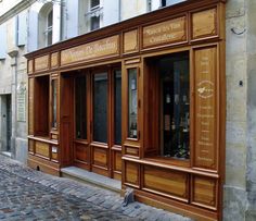 an old building with wooden doors and windows on a cobblestone street in europe