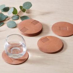 four coasters and a glass on a table