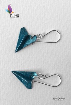 pair of blue earrings with silver hooks on white paper background and logo for turu