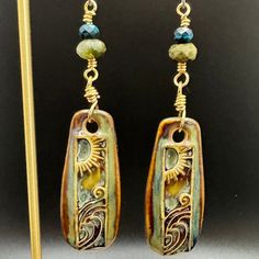 These fun boho earrings with ceramic artisan charms feature a sun and moon design. The earrings are accented with blue apatite and green agate semi-precious gemstones. They have gold artistic wire and hypoallergenic titanium ear wires in a matte silver color.  The colors in the photos are as close to the colors represented in person, but there might be a slight variation depending on computer or phone screens. Sun And Moon Design, Waves Design, Artistic Wire, Phone Screens, Spokane Wa, Blue Apatite, Green Agate, Wave Design, Moon Design