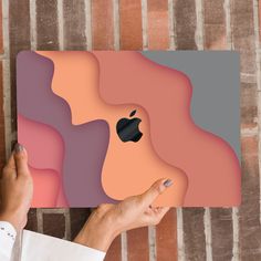 a person holding an apple logo on top of a wall