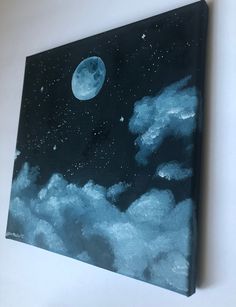 the painting is hanging on the wall with clouds and a full moon in the sky