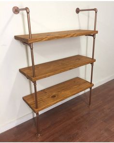 three wooden shelves on the wall with metal pipes attached to them and wood flooring