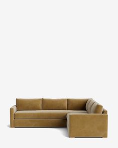 a tan couch and ottoman sitting on top of a white floor next to each other