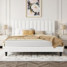 a large white bed sitting in a bedroom on top of a hard wood flooring