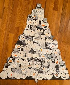 a christmas tree made out of paper with snowmen on it's sides and faces