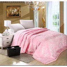 a bedroom with a pink comforter and chandelier