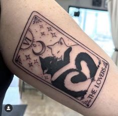 a person with a tattoo on their arm that has a cat and moon in it