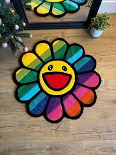 two colorful rugs on the floor next to a mirror with a smiling flower painted on it