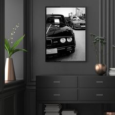 black and white photograph of cars parked in a parking lot next to bookshelves