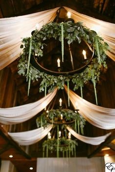 the ceiling is decorated with greenery and white draping for an elegant look