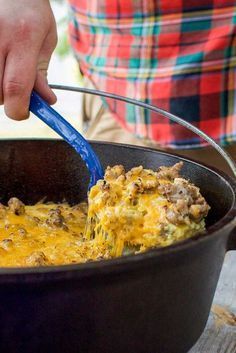 a person scooping some food out of a skillet