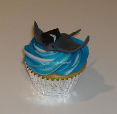 a cupcake with blue frosting and a shark on top