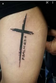 a person with a cross tattoo on their arm