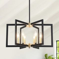 a chandelier hanging from the ceiling with four candles in an interlocked design