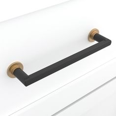 a black handle on a white cabinet with brass handles and knobs in the middle