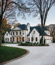 a large white house surrounded by trees and grass