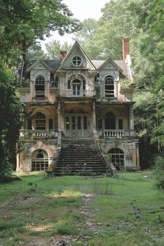 an old house in the woods with stairs leading up to it's second story