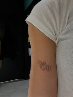 a woman's arm with a tattoo on it that has two hearts in the middle