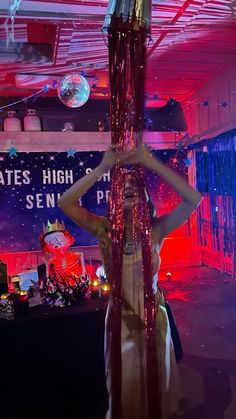 a woman is standing in front of a pole with streamers hanging from it's sides