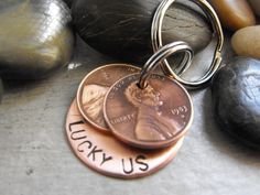 two penny key chains with the words lucky us on them