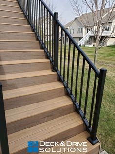 a deck and railing installed on a home's front porch with black handrails