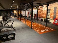 an indoor gym with rows of exercise equipment and orange rubber flooring that says it's time to start