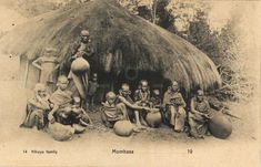 an old black and white photo of people in front of a hut