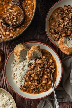 three bowls filled with beans and rice on top of a wooden table next to bread