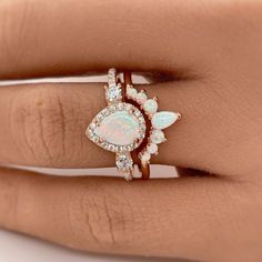 a woman's hand with an opal and diamond ring