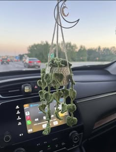 a car dashboard with an electronic device hanging from it's center console, and a cell phone holder attached to the dash board