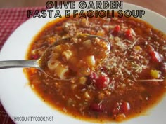 a white bowl filled with pasta and sauce on top of a red checkered table cloth