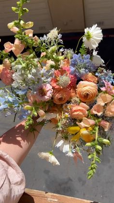 a person holding a bouquet of flowers in their hand