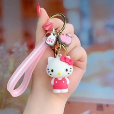 a hello kitty keychain with a pink ribbon attached to it's wrist